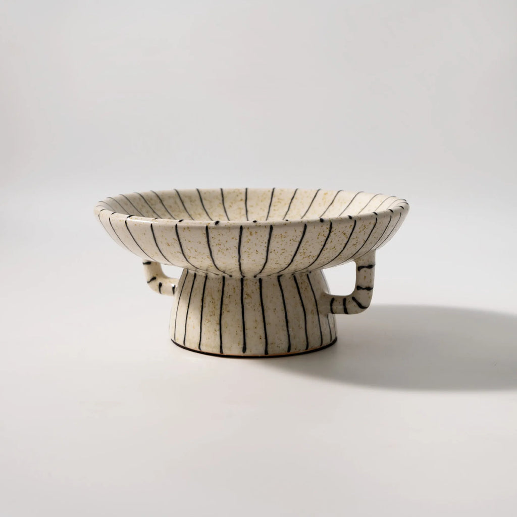 Retro style black and white striped synthetic resin fruit plate on a table.