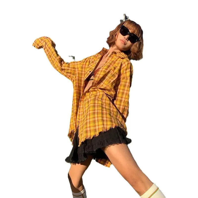 A man or woman wearing a loose-fitting yellow plaid cardigan-style shirt.