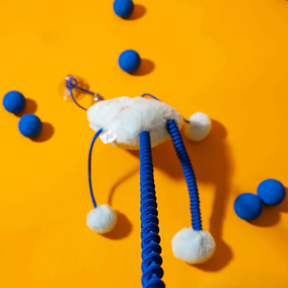 Blue plush cat toy ring with elastic rope and bell on a white background