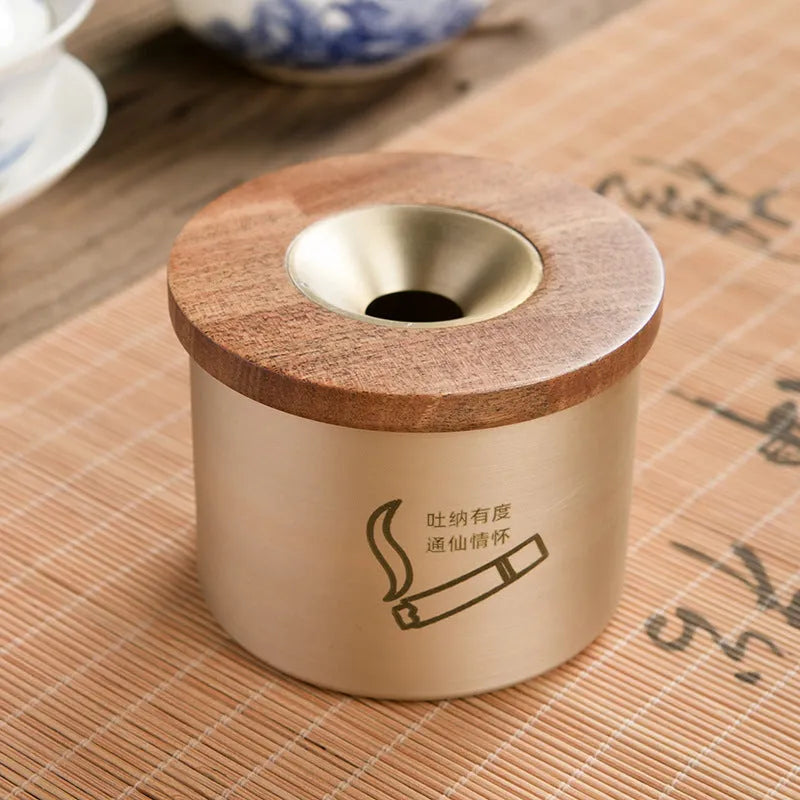 Retro-style solid copper ashtray with a wooden lid featuring a centre hole, shown in brass and black wood or brass and red wood.