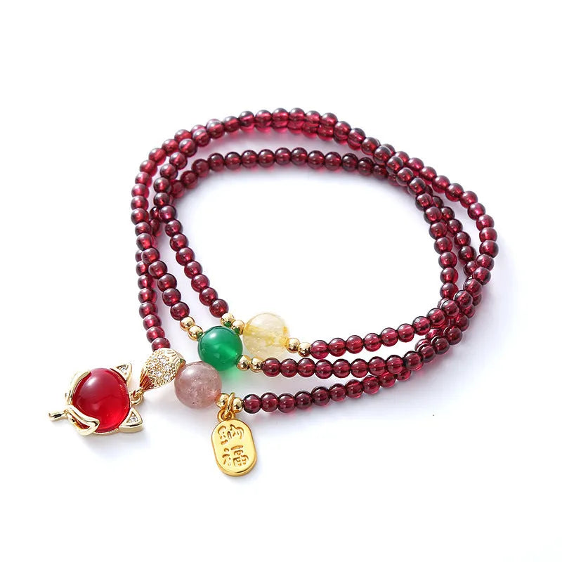 Purplish red garnet fox bracelet on an adjustable rope for women.