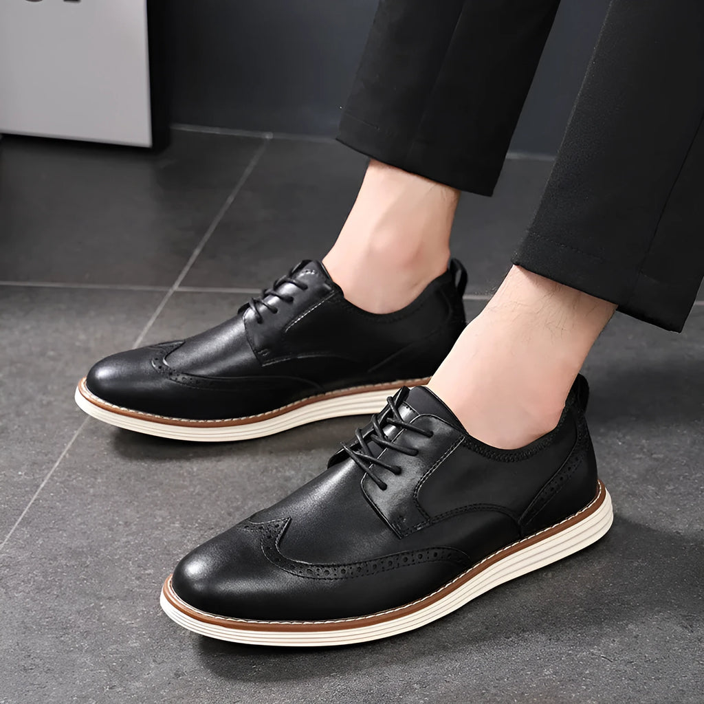 Men's black slip-on business casual shoes with round toe and carved detail on a white background.