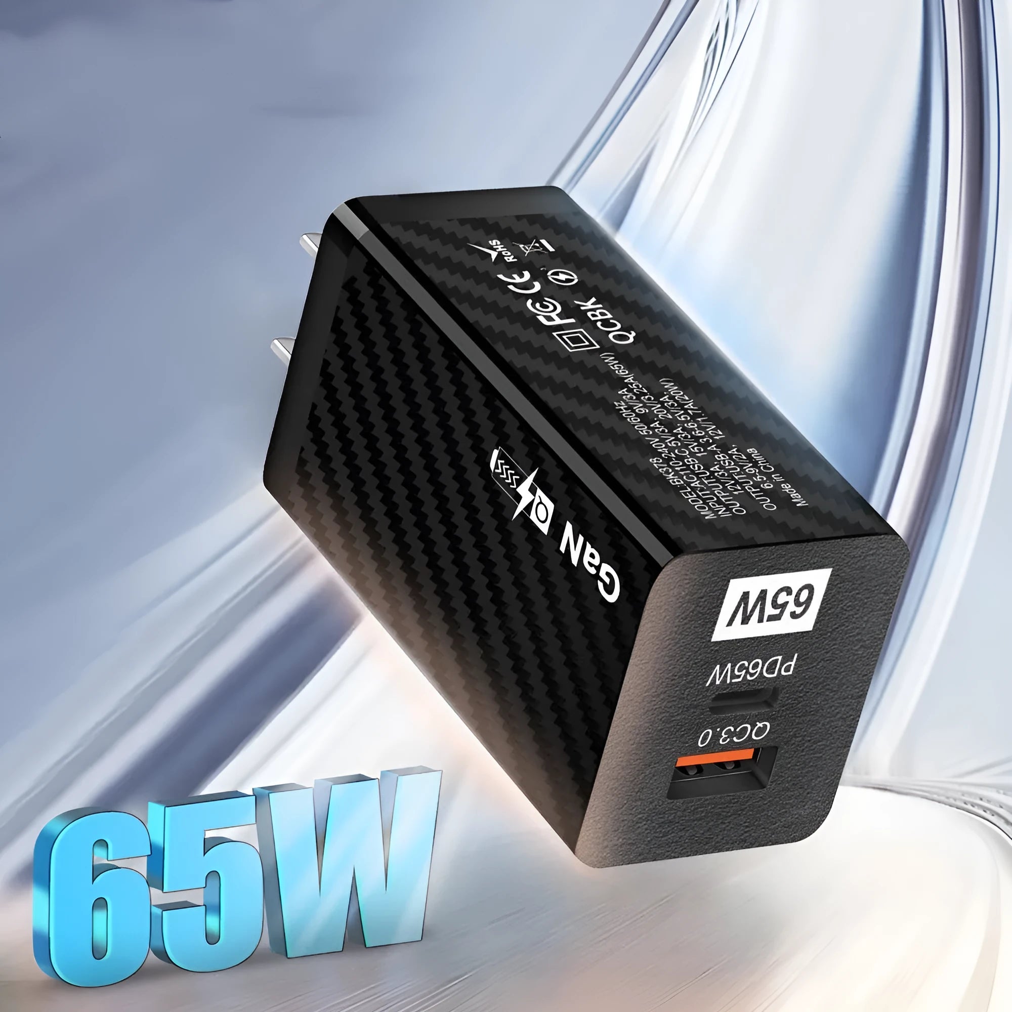 White GaN 65W USB-C fast charger plug with UK, EU, and US attachments on a desk.