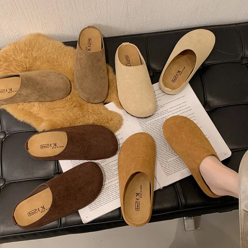 A pair of soft, flat apricot-coloured slip-on slippers with a square toe and microfiber upper on a plain background.