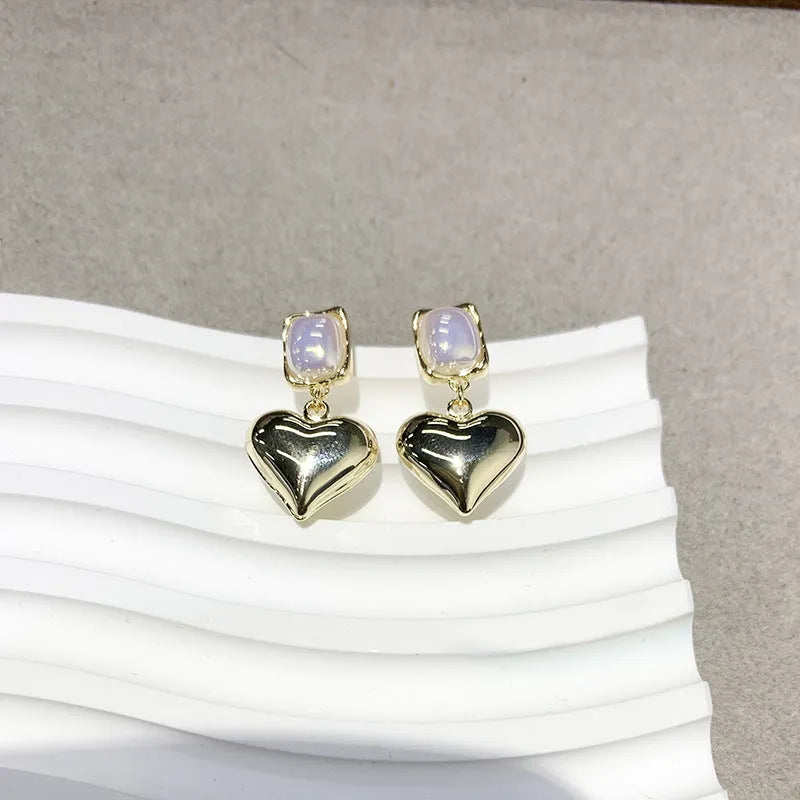 Small gold heart earrings with metal construction and post backing