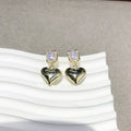 Small gold heart earrings with metal construction and post backing