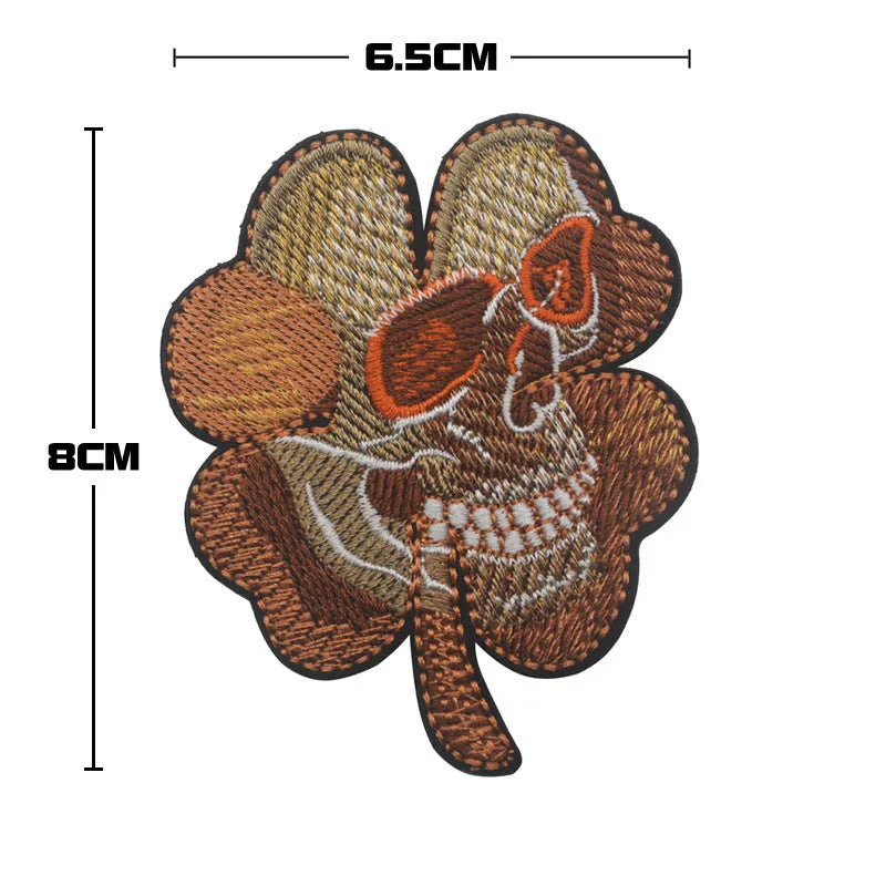 Outdoor embroidered fabric badge with green clover design on a velcro strip backing.
