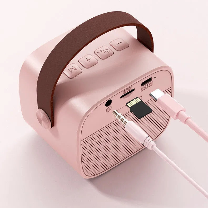 Compact portable Bluetooth speaker in blue, pink, or white with built-in microphone and USB charging cable