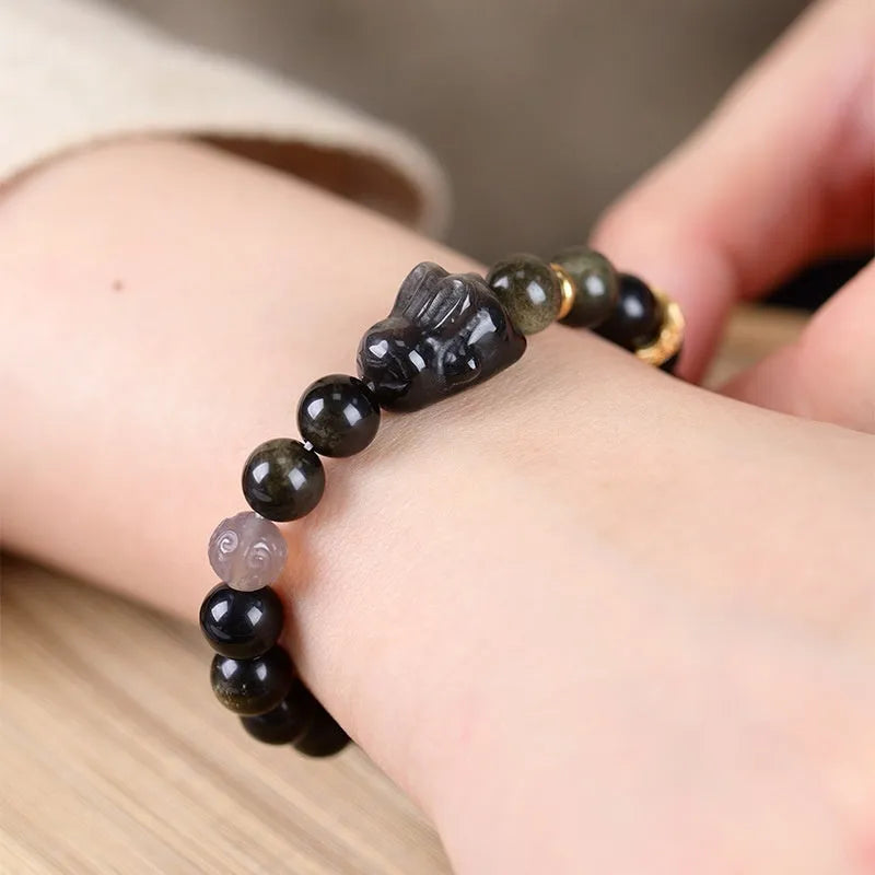 Handmade national style bracelet with a lying rabbit charm, grey agate, and metal details on a wrist.