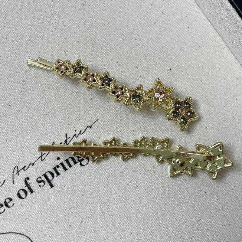 Gold electroplated rhinestone barrettes with side clip design featuring star and letter charms