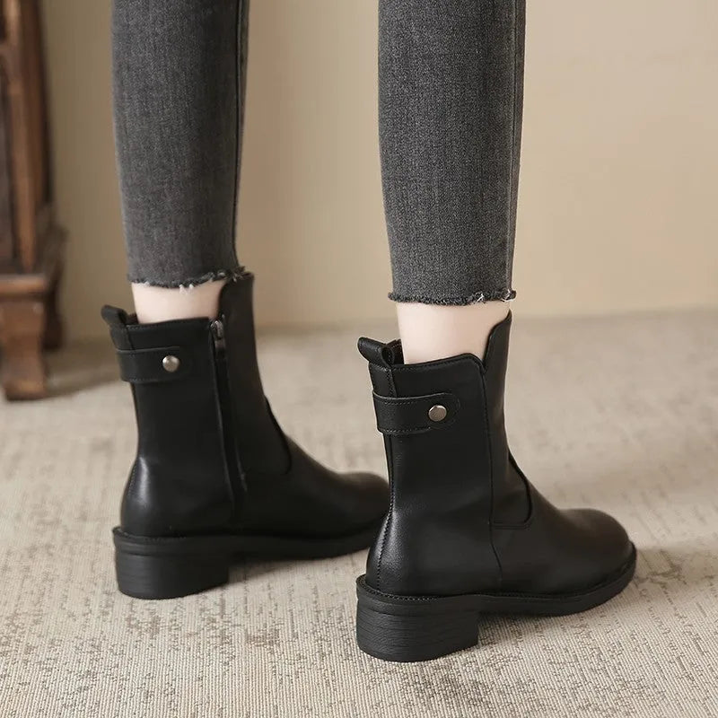 Black women's low heel ankle boots with a side zip and round toe on a rubber sole.