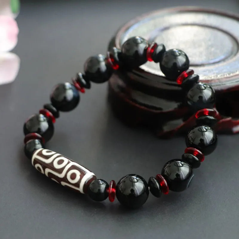 Black agate dzi bead bracelet with hand-woven construction and geometric 11mm beads