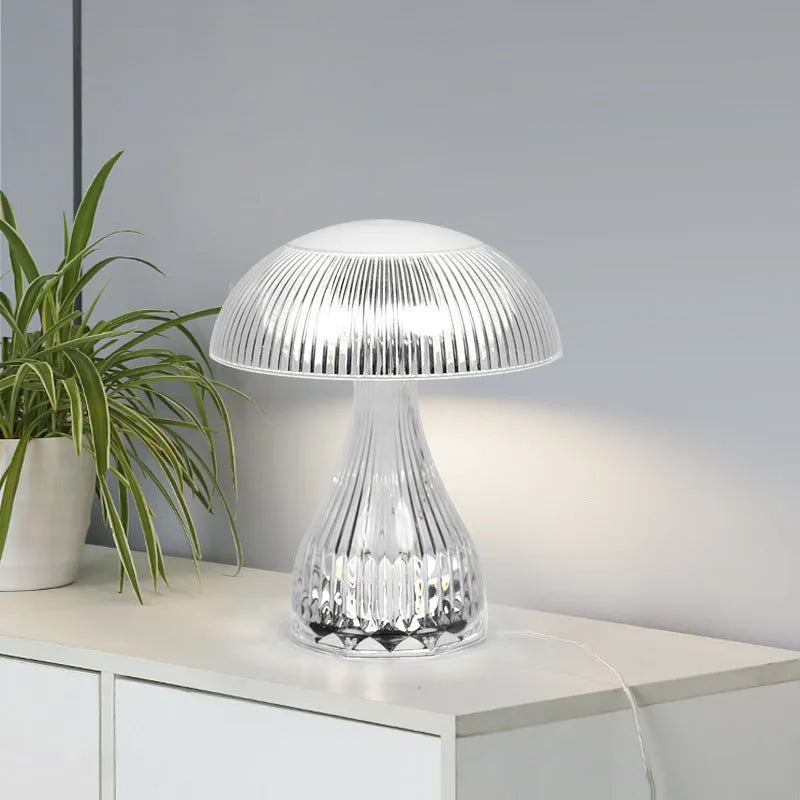 Small white rechargeable table lamp with acrylic body and USB cable, showing three colour light settings.