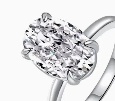 Women's oval silver ring with a four-claw setting holding a hand-cut gemstone.