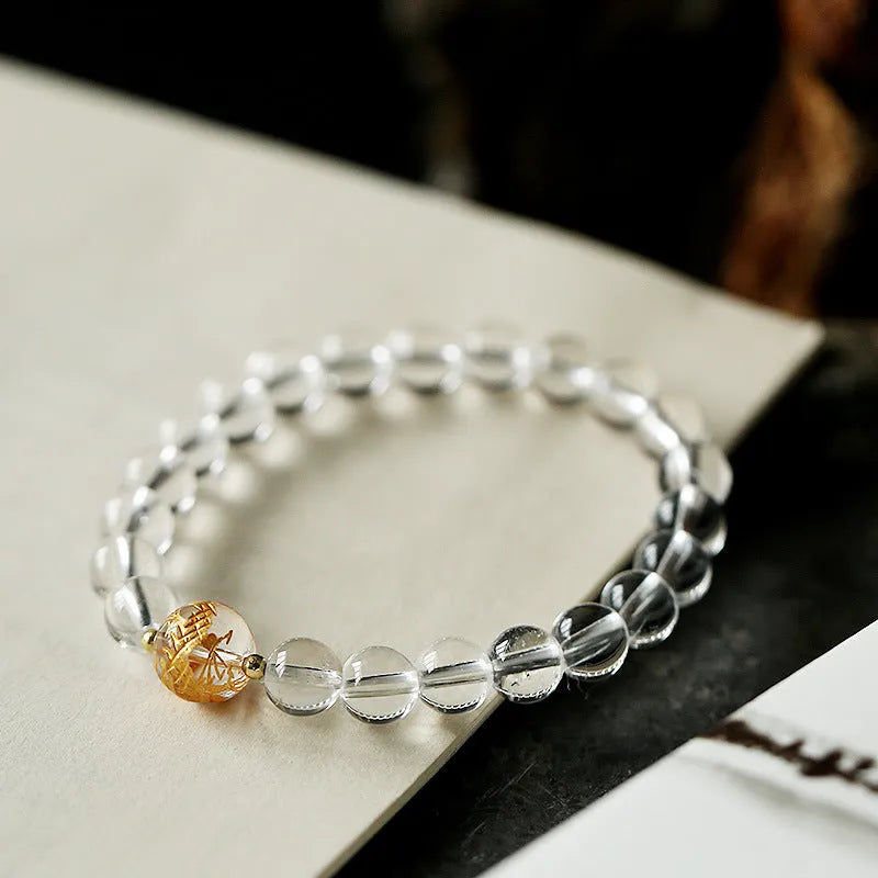 Geometric obsidian and white crystal bracelet with black agate beads and golden dragon charm on wrist