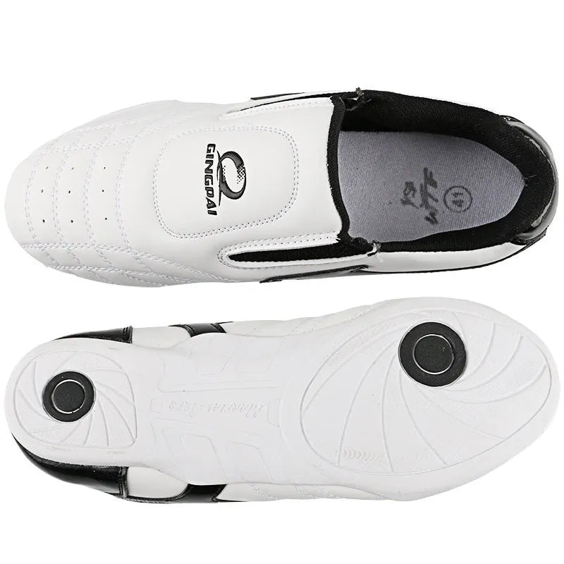 Black and white children's martial arts training shoes with soft bottom construction and widened design