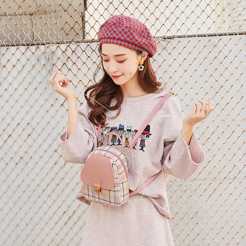 A black PU one shoulder diagonal phone bag worn crossbody, also shown held in hand.