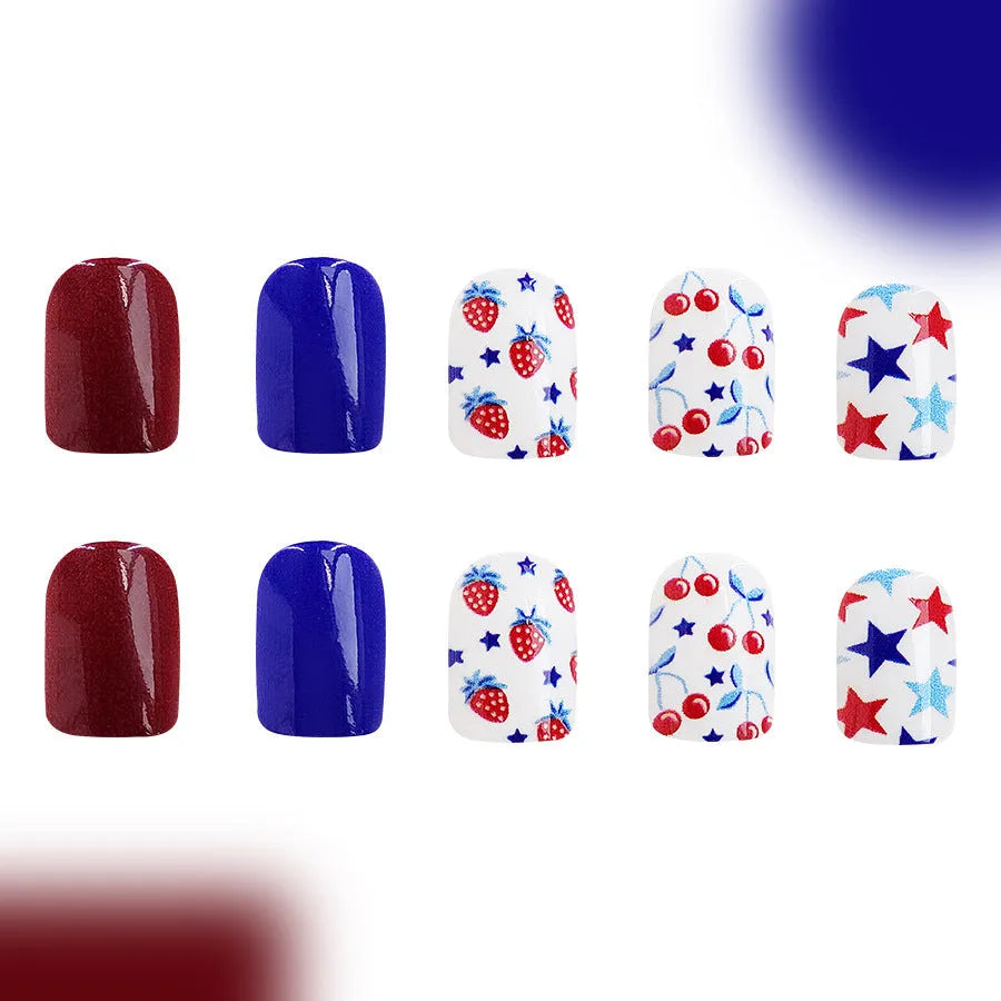Short glossy false nails with strawberry and cherry patterns in red and blue colour combinations