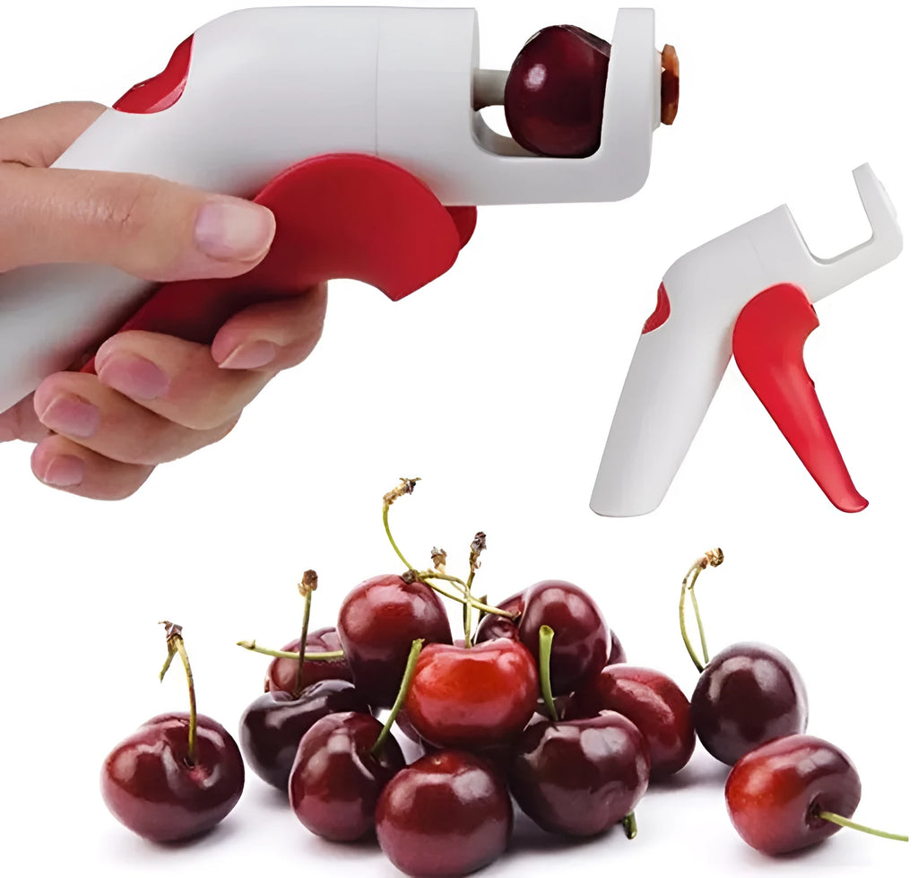 Red and black manual cherry pitter tool with detachable stone catcher on a kitchen worktop.