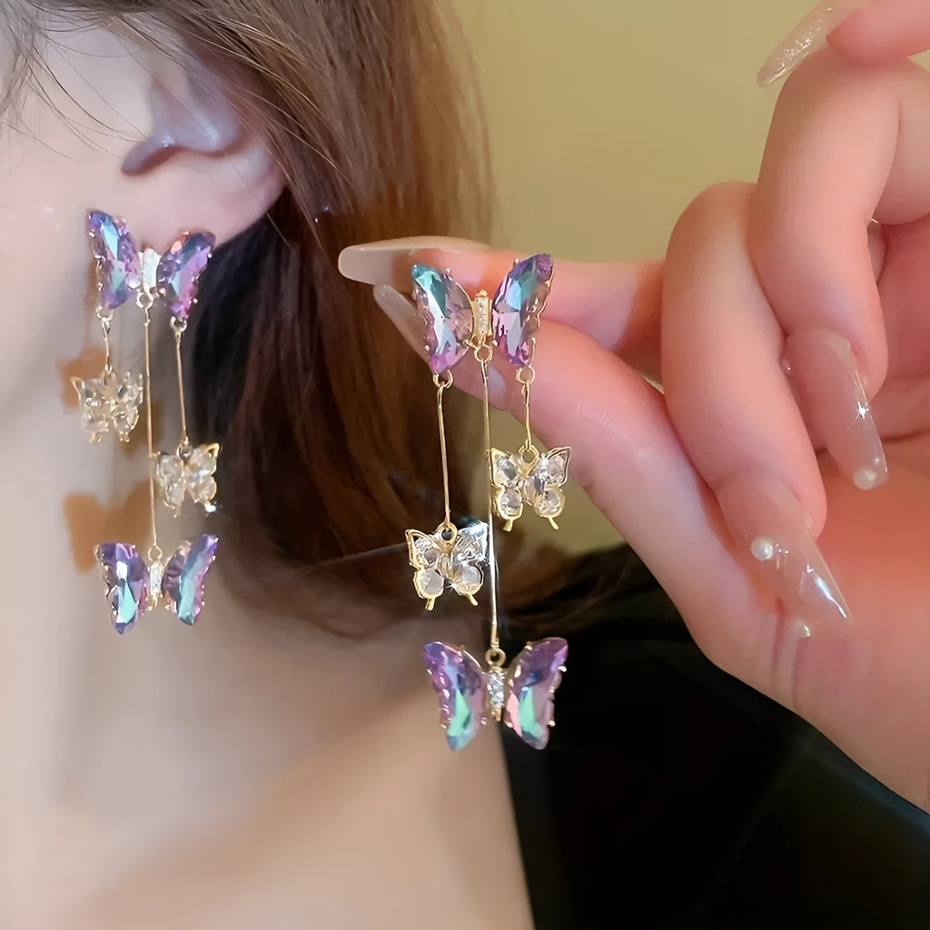 Silver needle alloy drop earrings featuring a blue purple butterfly design with crystal accents and tassel details.