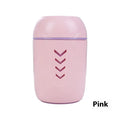 Round blue portable air purifier and aromatherapy diffuser unit with USB cable on a wooden desk.