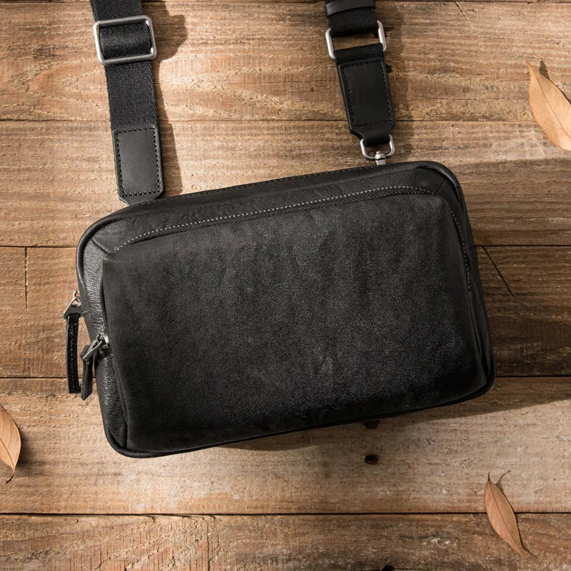 Black cowhide leather shoulder bag with zipper closure and interior organisation pockets