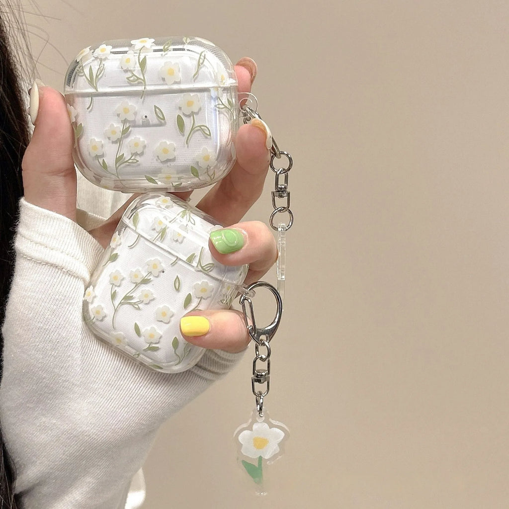 Transparent white floral TPU protective case for Apple AirPods headphones on a table.