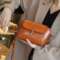 Women's brown cowhide leather shell messenger bag with cross-body strap and multiple internal compartments