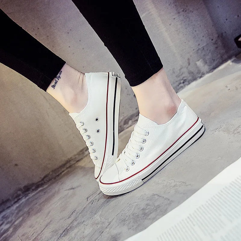 Women's casual canvas shoes in solid colours on a flat sole, showing lace-up fastening.