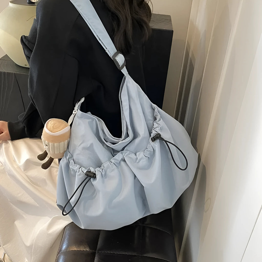 Green ultra-light pleated polyester crossbody bag showing split pocket and phone compartment.