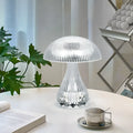 Small white rechargeable table lamp with acrylic body and USB cable, showing three colour light settings.