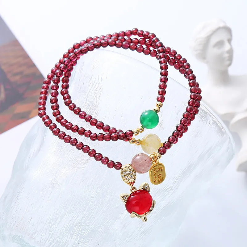Purplish red garnet fox bracelet on an adjustable rope for women.