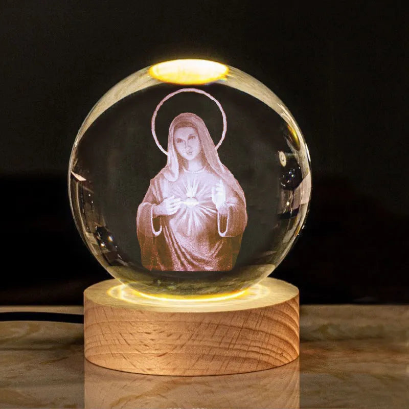 White crystal ball ornament on wooden base with religious symbols and warm light illumination