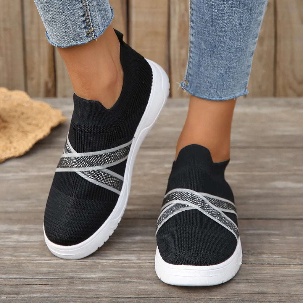 Black women's flat casual shoes with fabric mesh uppers, tassel detail, and a rubber sole.