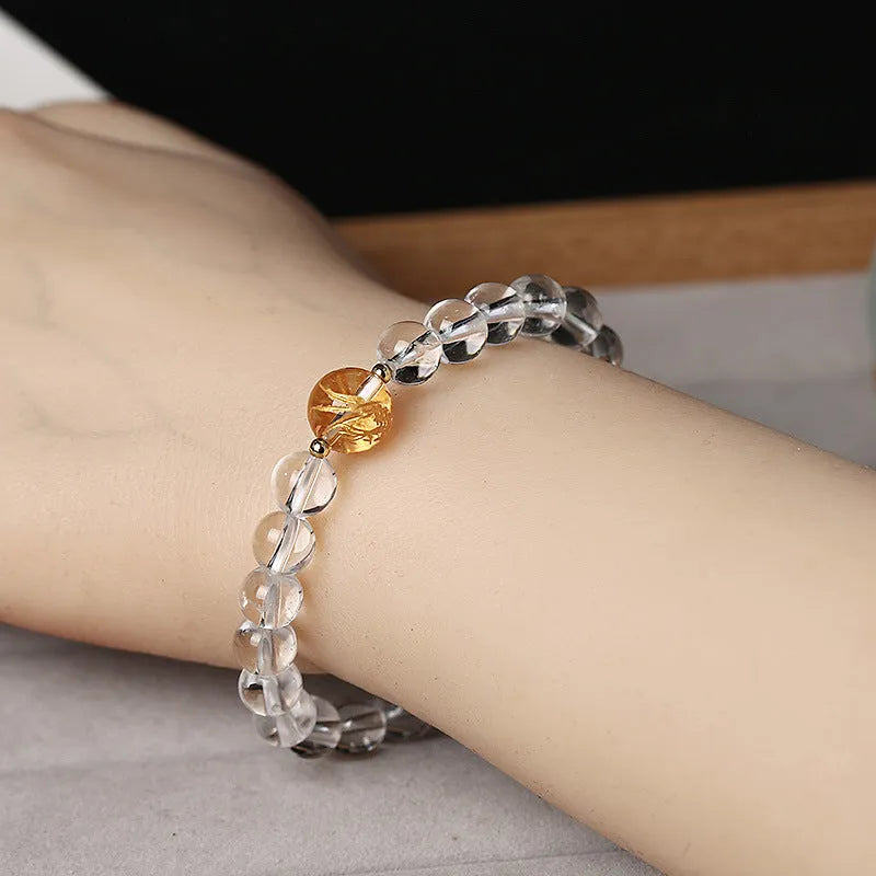 Geometric obsidian and white crystal bracelet with black agate beads and golden dragon charm on wrist