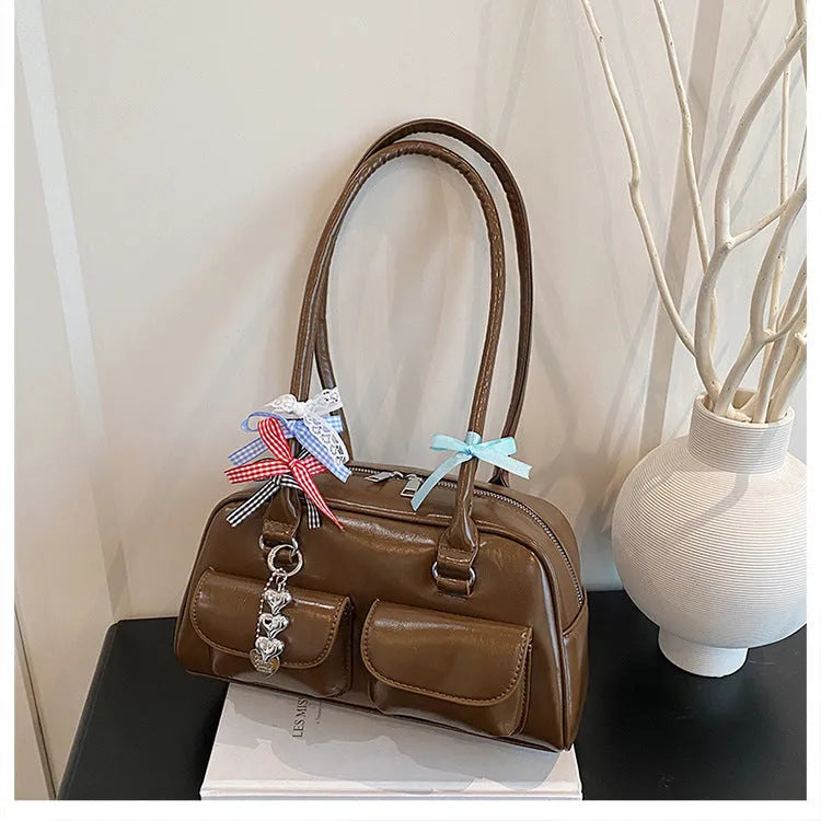 Retro brown PU leather women's pillow-shaped shoulder bag with a flap closure and double strap.