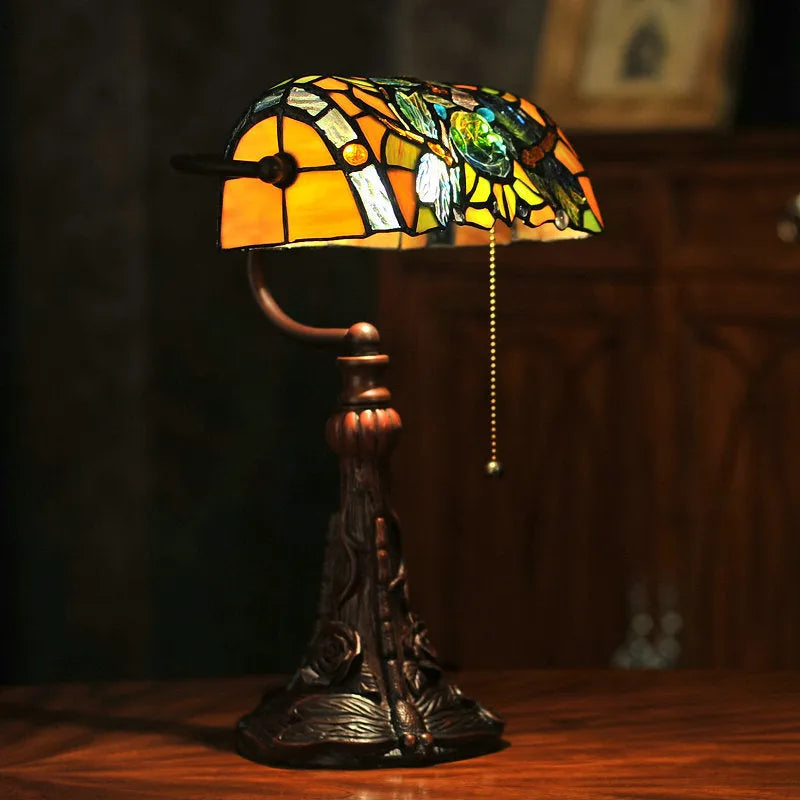 10-inch tall Tiffany table lamp with multi-coloured stained glass shade on a resin base.