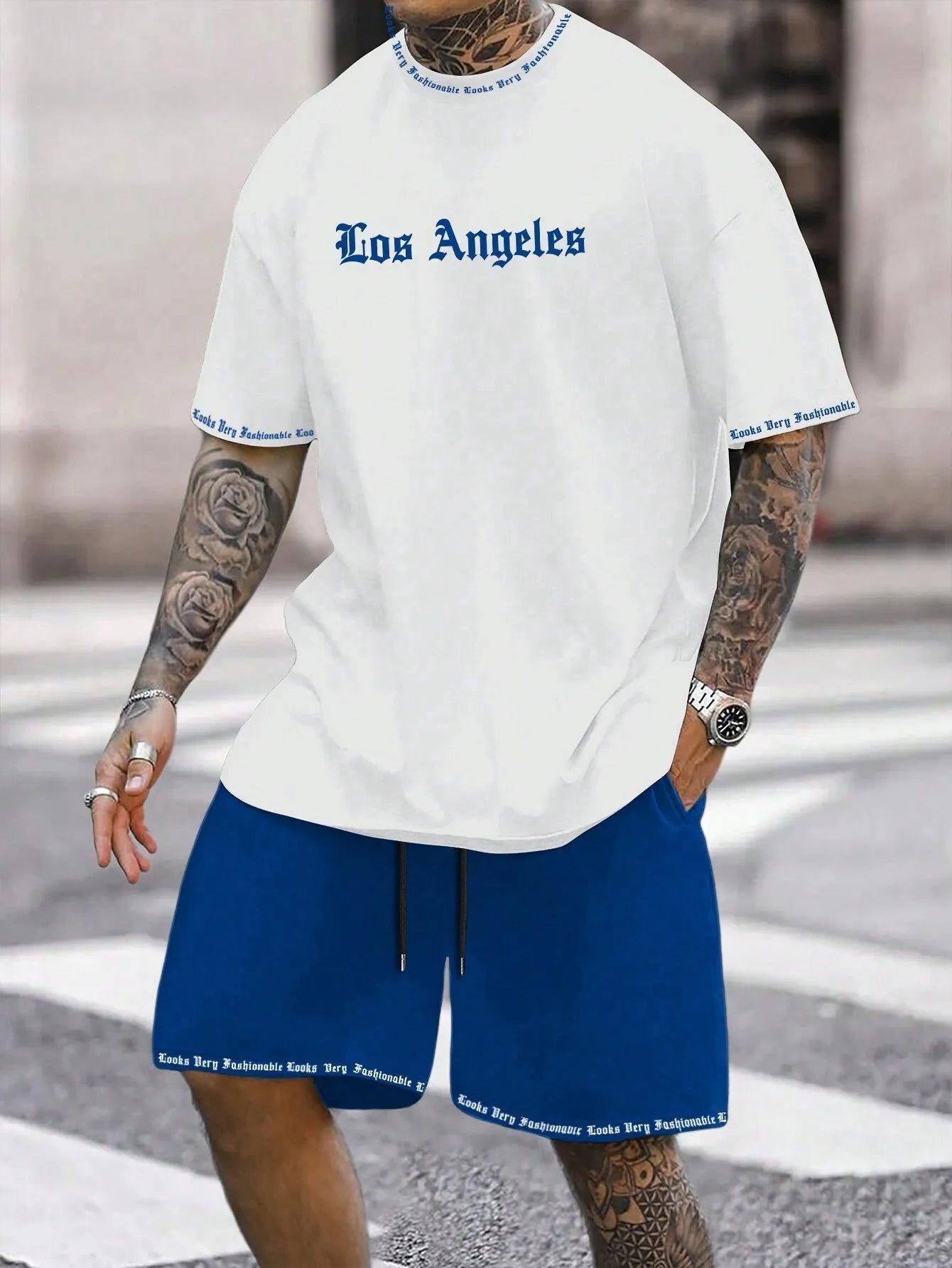 Man wearing a blue printed short-sleeve top and matching shorts from a two-piece sports casual set.