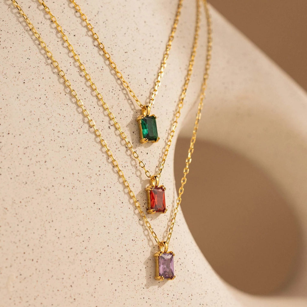 Titanium steel necklace with rectangular birthstone pendant and adjustable O-link chain on a neutral background.