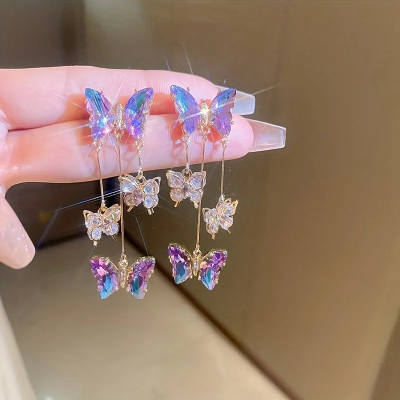 Silver needle alloy drop earrings featuring a blue purple butterfly design with crystal accents and tassel details.