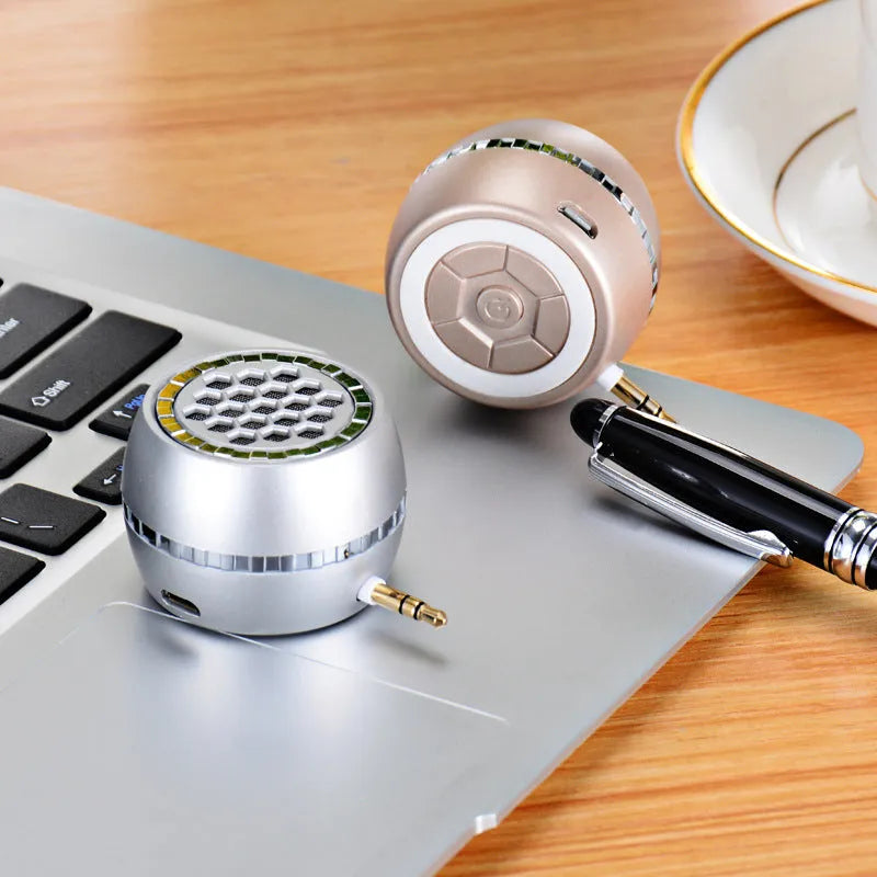Black universal external amplifier speaker with a single channel, powered by a 5V mobile phone charger.