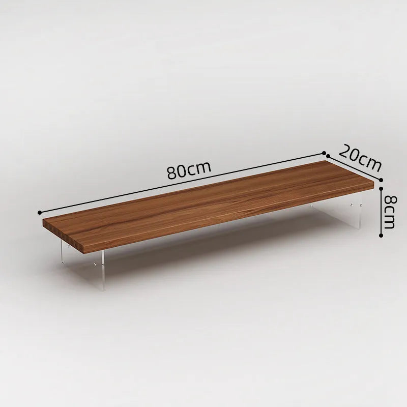 Black computer riser with acrylic legs on desk under monitor