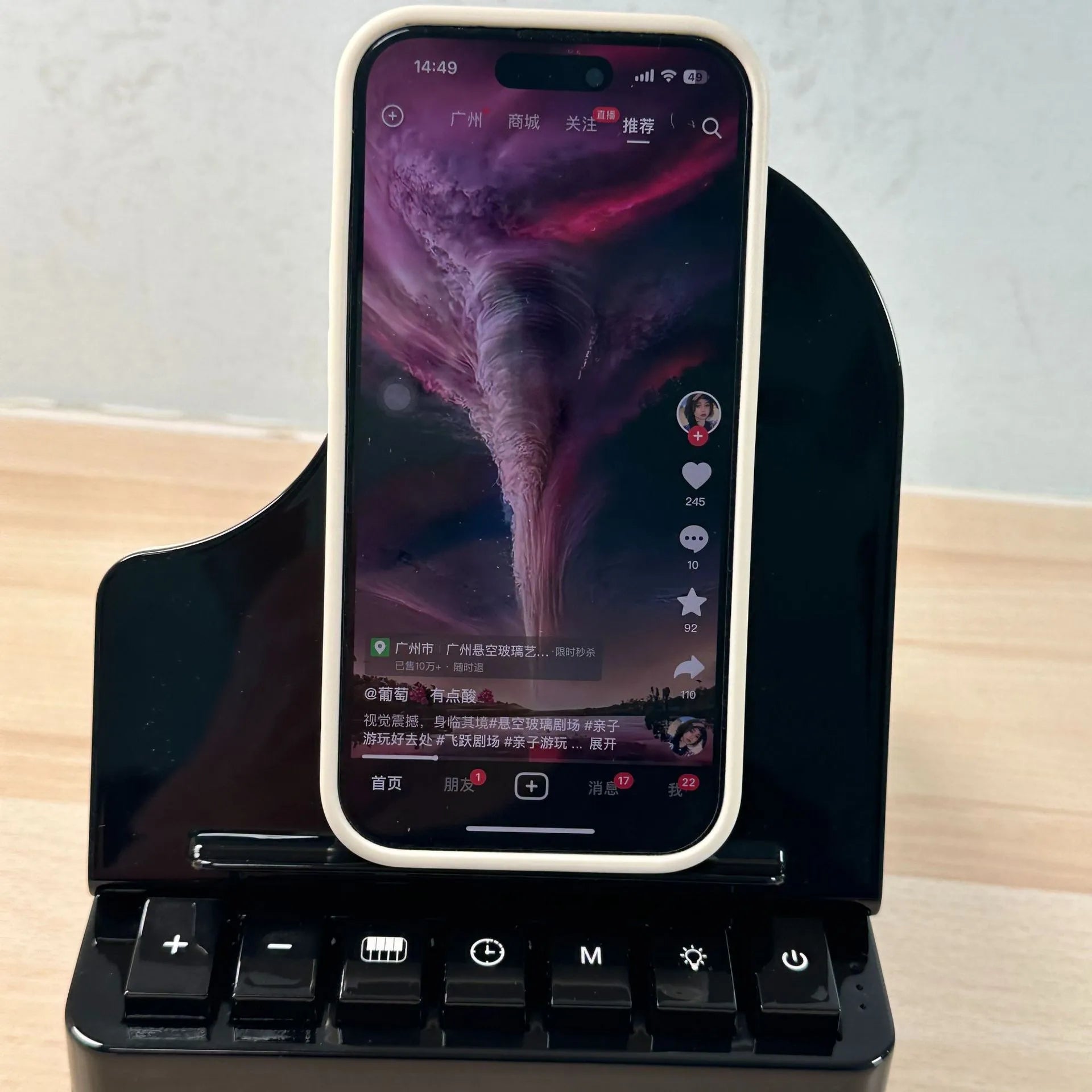 Black 3-in-1 Bluetooth speaker with wireless charger and phone holder on a desk