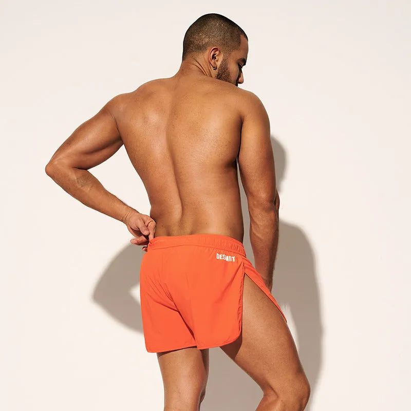 Men's loose beach shorts in orange, fluorescent green and black colours with elastic polyester fabric