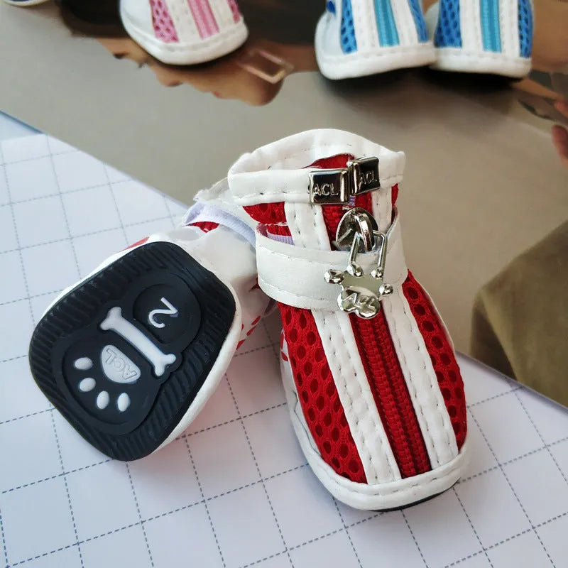 Set of four blue cloth dog shoes with zippers for small breed pets on a white background
