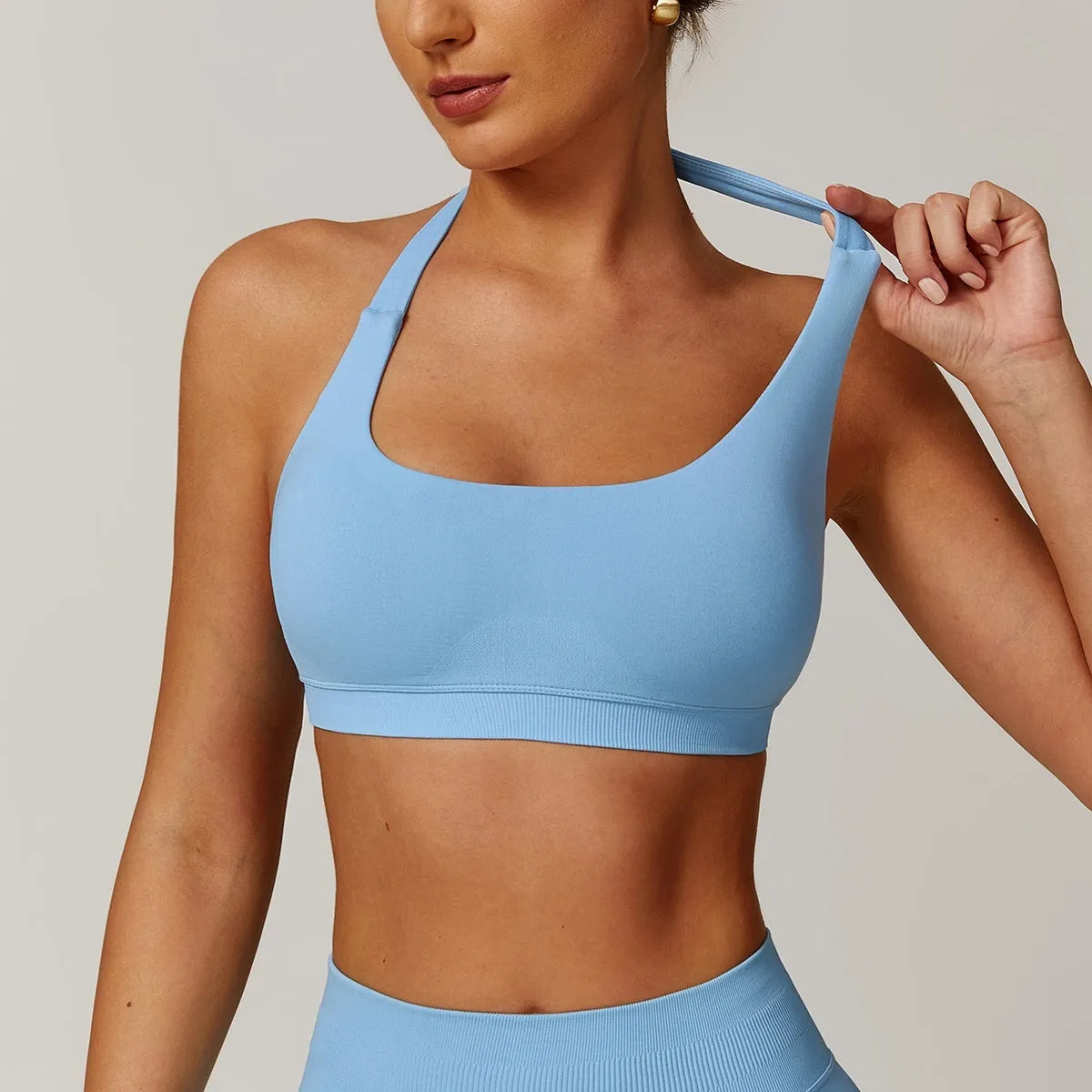 Women's black halter neck sports bra with hollow cutout design and medium support for yoga