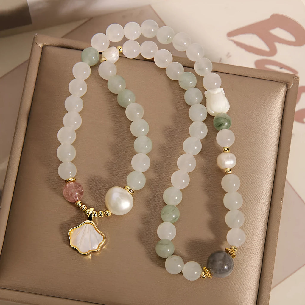 Women's crystal bracelet with a large green ginkgo leaf pendant, gold metalwork, and sparkling rhinestones.