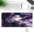 Large black gaming mouse pad with stitched edges and a printed pattern on a desk