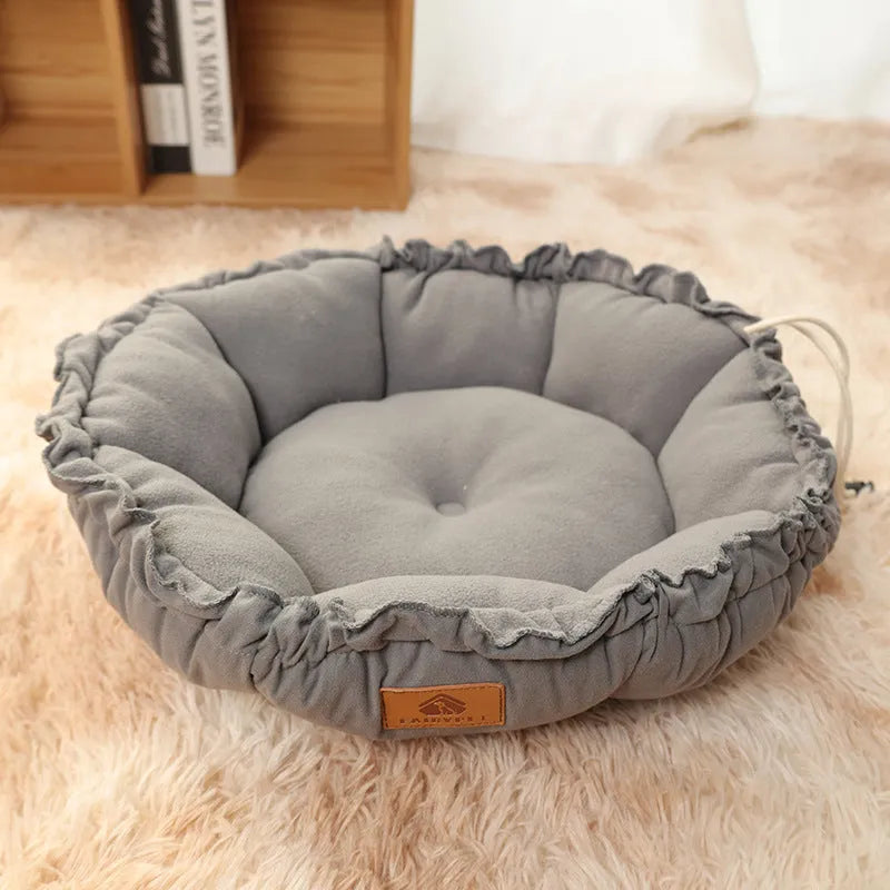 Grey reversible donut-shaped cat bed for indoor pets on a wooden floor.