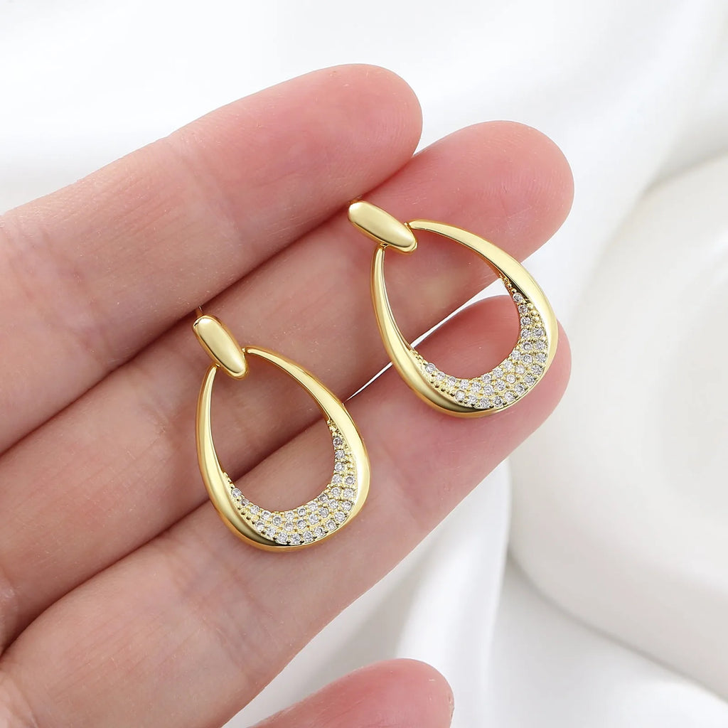 Yellow gold geometric women's drop earrings with a ring design and zircon detail on a white background.